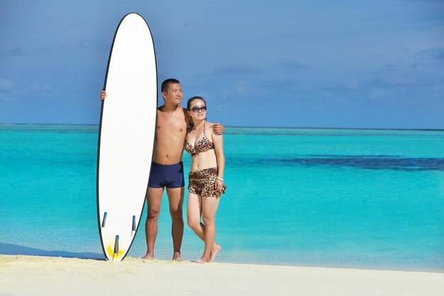 Una giovane coppia asiatica felice si diverte e trascorre un periodo romantico in estate su una bellissima spiaggia di sabbia bianca.