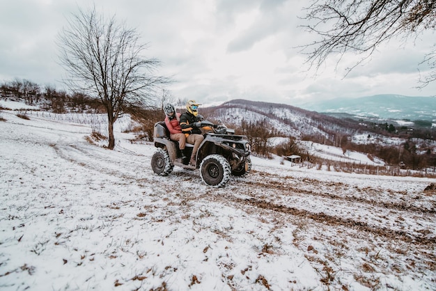 Una giovane coppia avventurosa abbraccia la gioia dell'amore e il brivido mentre guidano un quad attraverso il