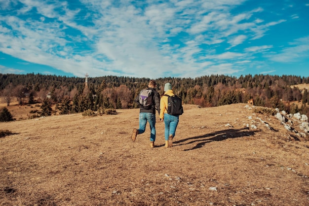 Una giovane coppia che fa un'escursione divertendosi sulla montagna