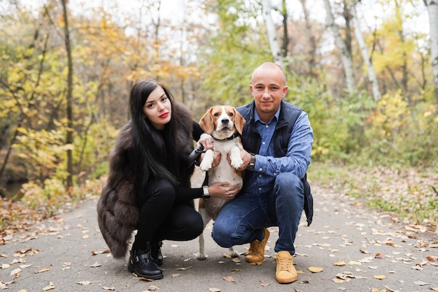 Una giovane coppia che porta a spasso un cane nel parco