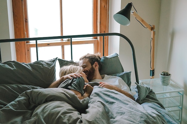 Una giovane coppia che si rilassa sul letto a casa