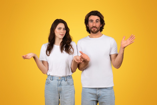 Una giovane coppia confusa con le mani alzate che mostrano incertezza e gesti interrogativi