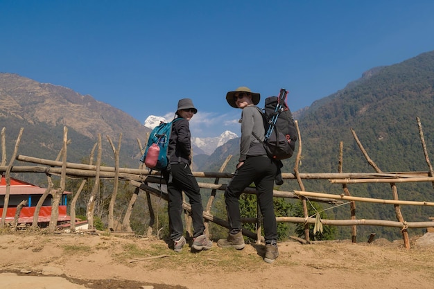 Una giovane coppia di viaggiatori che fa trekking nel punto panoramico di Poon Hill a Ghorepani Nepalx9