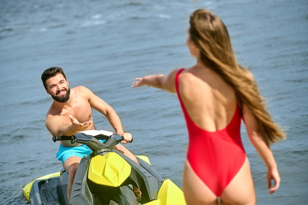 Una giovane coppia in costume da bagno su uno scooter d'acqua