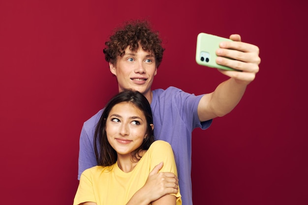 Una giovane coppia in magliette colorate con un telefono Stile giovanile