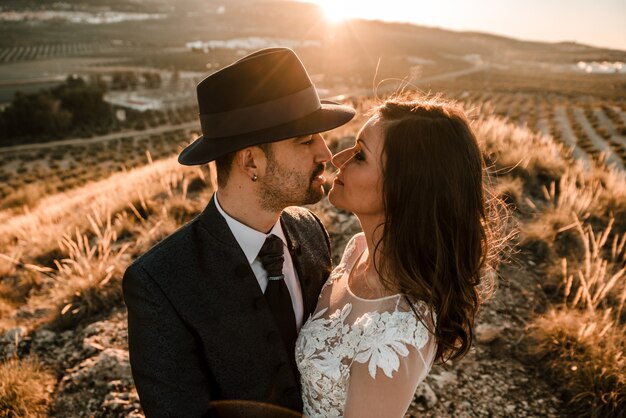 Una giovane coppia in un abito da sposa con un tramonto sullo sfondo