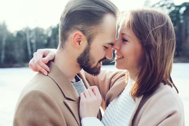 Una giovane coppia sorridente che ha una storia d'amore sulla riva del fiume