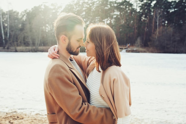 Una giovane coppia sorridente che ha una storia d'amore sulla riva del fiume