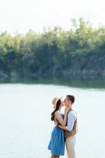 Una giovane coppia, un ragazzo e una ragazza, cammina vicino a un lago di montagna circondato da rocce di granito