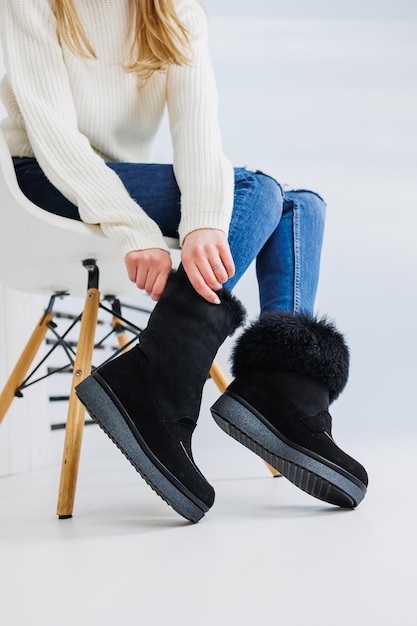 Una giovane donna alla moda in jeans alla moda e scarpe in pelle alla moda è in piedi su una piastrella bianca Collezione alla moda di scarpe autunnali da donna Primo piano di gambe femminili in scarpe