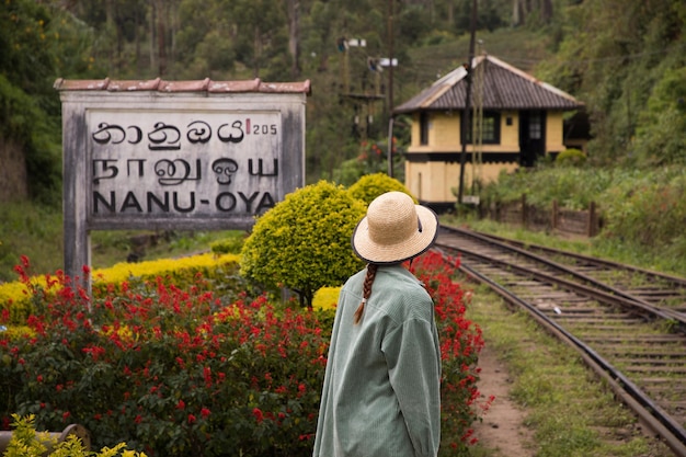 Una giovane donna alla stazione ferroviaria dello sri lanka è in piedi con la schiena
