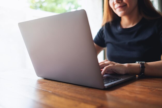 Una giovane donna asiatica che utilizza e lavora al computer portatile