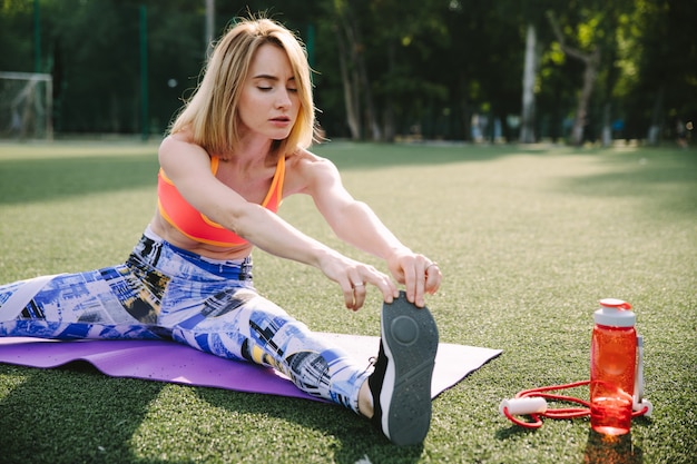 Una giovane donna attraente a praticare yoga e stretching all'aperto