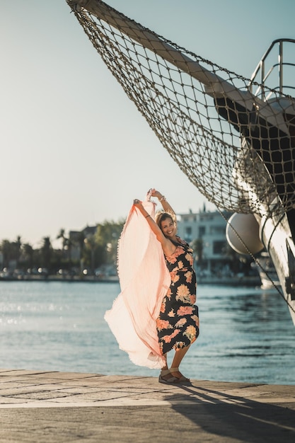 Una giovane donna attraente che si diverte con la sciarpa vicino al meraviglioso mare mentre si gode una vacanza estiva.