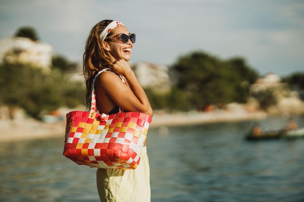 Una giovane donna attraente in bikini si diverte sulla spiaggia e si gode le vacanze estive.