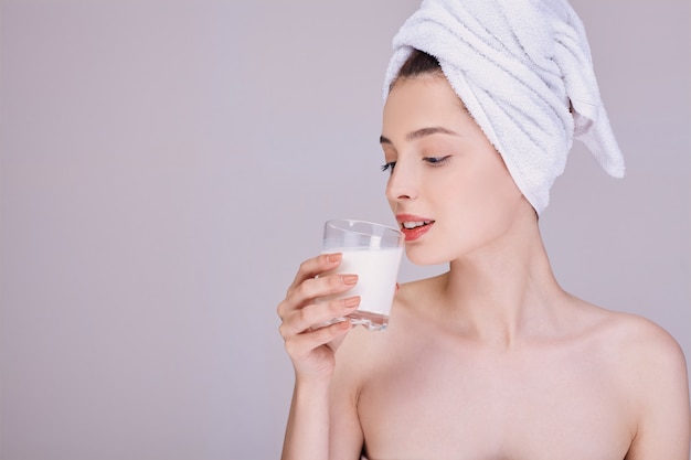 Una giovane donna beve il latte dopo la doccia.