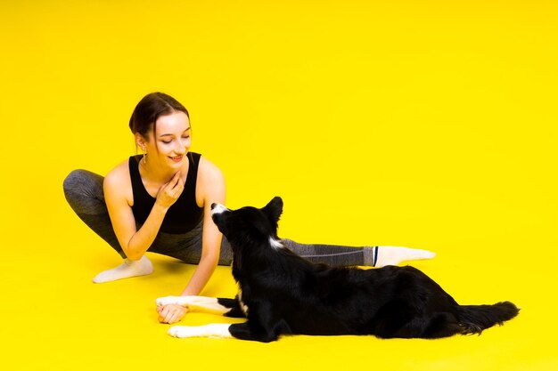 Una giovane donna carina bacia e abbraccia il suo cucciolo border collie cane amore tra proprietario e cane