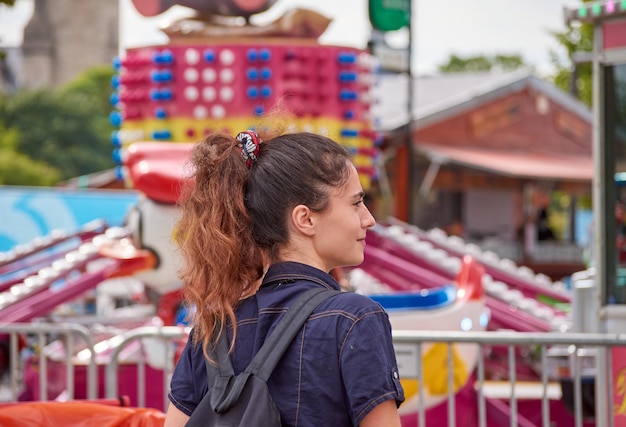 Una giovane donna caucasica che cammina in un parco di divertimenti