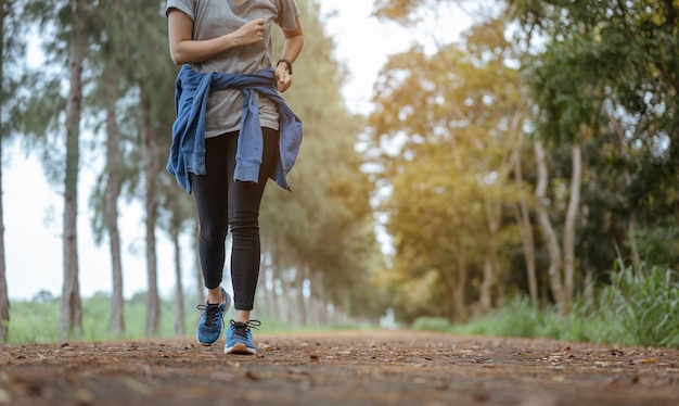 Una giovane donna che corre al parco naturale.