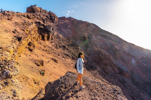 Una giovane donna che guarda il cratere del vulcano Teneguia lungo il percorso