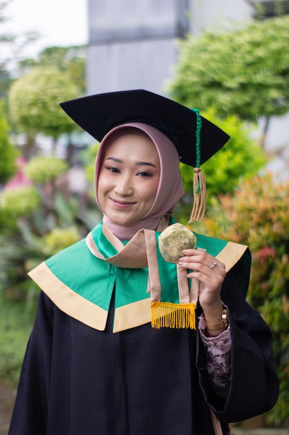 Una giovane donna che indossa una toga con una felice espressione sorridente Concetto di graduazione