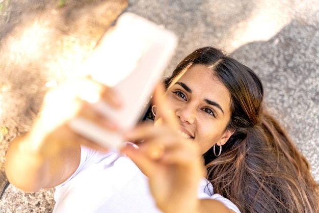 Una giovane donna che prende un selfie e sorridere