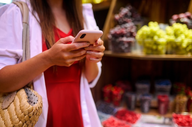 Una giovane donna che sceglie la frutta in un negozio