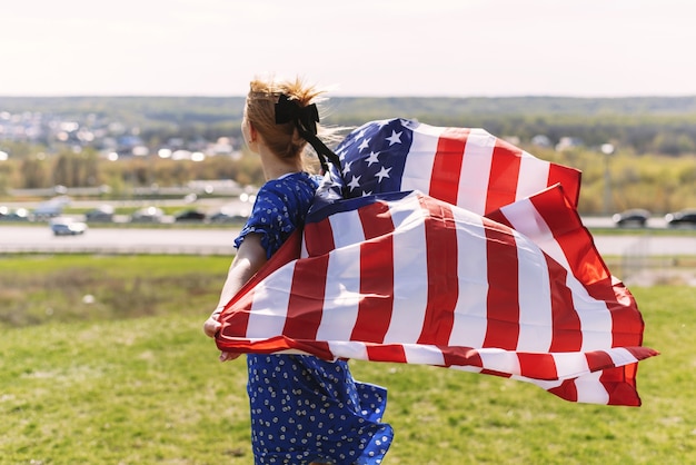 una giovane donna con la bandiera nazionale degli Stati Uniti celebra il giorno dell'indipendenza