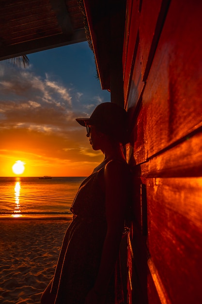 Una giovane donna con un berretto al West End Tramonto nel Mar dei Caraibi, Roatan Island. Honduras