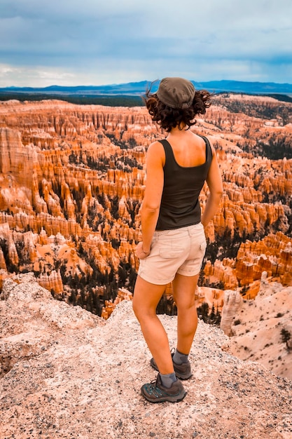 Una giovane donna con una maglietta verde che guarda il parco nazionale da Bryce Point