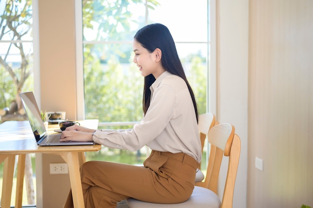 Una giovane donna d'affari che lavora con il suo computer portatile in una caffetteria