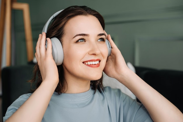 Una giovane donna di mezza età sorridente che indossa cuffie wireless ascolta la musica Musical Bliss Middl