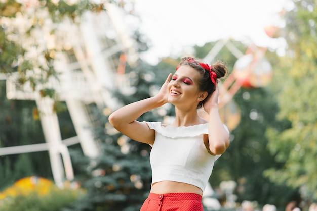 Una giovane donna è felice in un parco divertimenti in estate