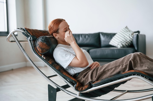 Una giovane donna è seduta su una seduta di psicoterapia