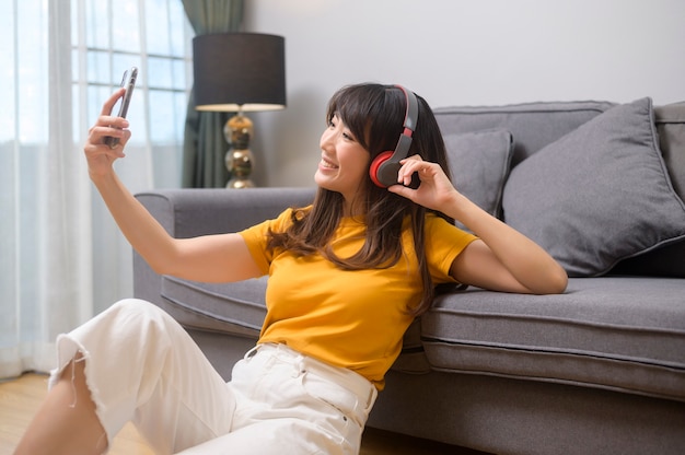 Una giovane donna felice che ascolta musica e si rilassa a casa