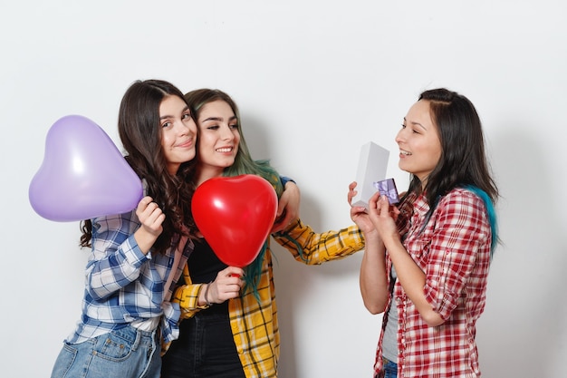 Una giovane donna felice prende un regalo di festa dai suoi amici