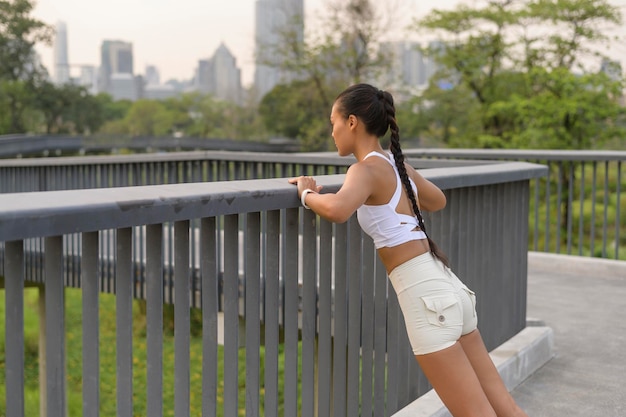 Una giovane donna fitness in abbigliamento sportivo che si esercita nel parco cittadino Salute e stili di vita