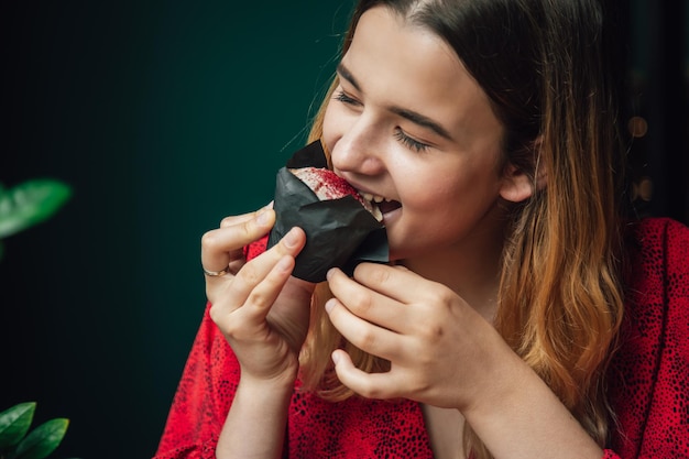 Una giovane donna gode di un muffin al lampone in un caffè