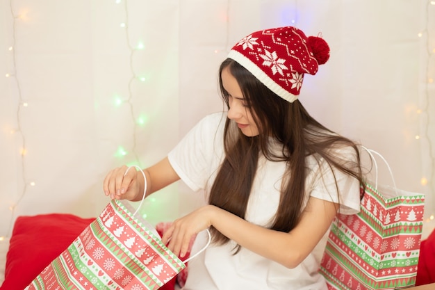 Una giovane donna guarda in una tasca con i regali di Natale