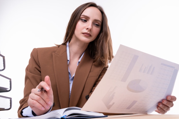 Una giovane donna in giacca e cravatta che lavora alla scrivania