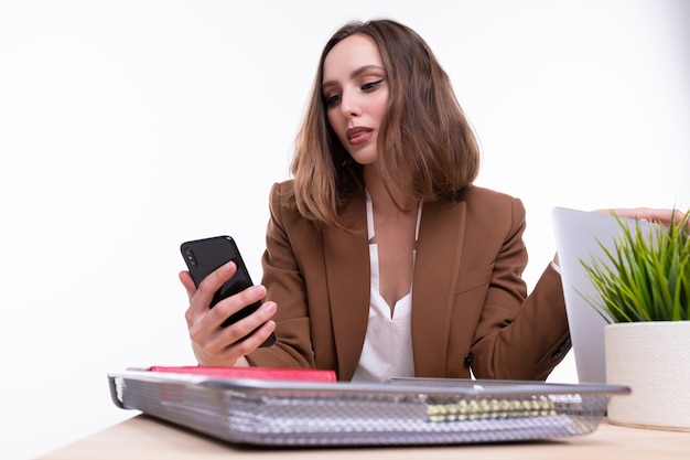 Una giovane donna in giacca e cravatta sta parlando al telefono