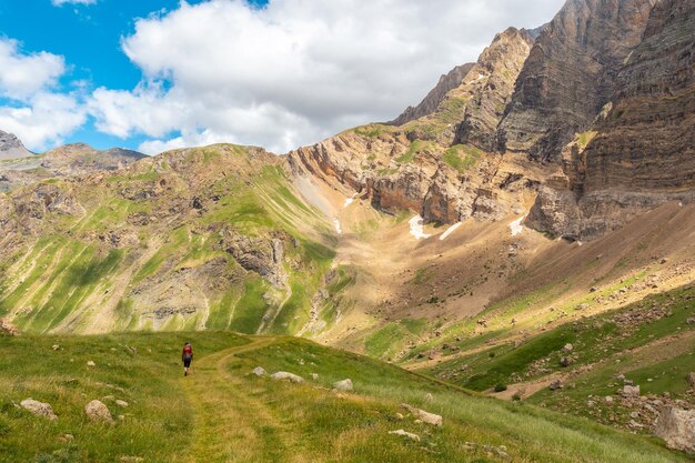 Una giovane donna in montagna che fa trekking con suo figlio nello zaino nei Pirenei della Val Ripera