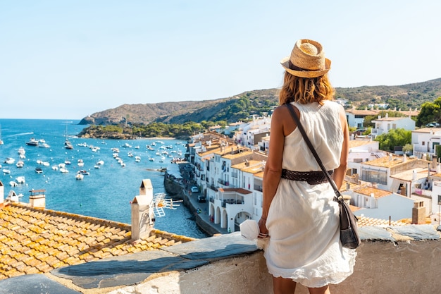 Una giovane donna in vacanza guardando la città di Cadaques da un punto di vista, Costa Brava della Catalogna, Gerona, Mar Mediterraneo. Spagna