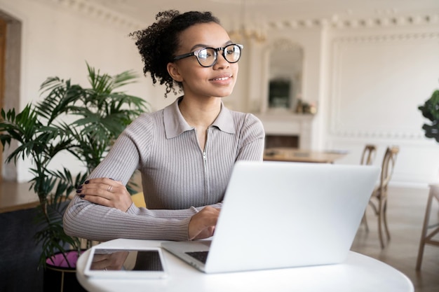 Una giovane donna intelligente con gli occhiali un libero professionista in un posto di lavoro in ufficio un computer portatile