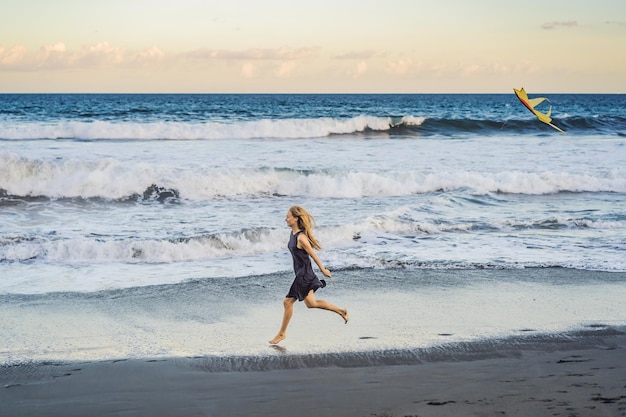 Una giovane donna lancia un aquilone sulla spiaggia Sogna aspirazioni progetti futuri