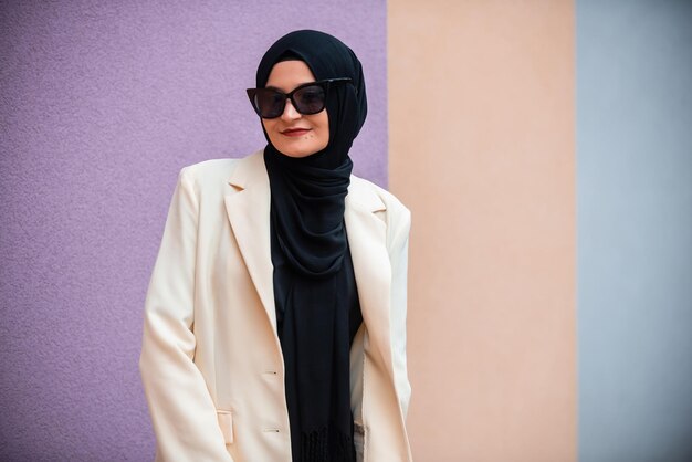 Una giovane donna musulmana in hijab alla moda isolata sullo sfondo