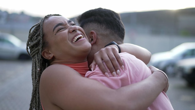 Una giovane donna nera felice che abbraccia un membro della famiglia La sorella brasiliana abbraccia il fratello sudamericano