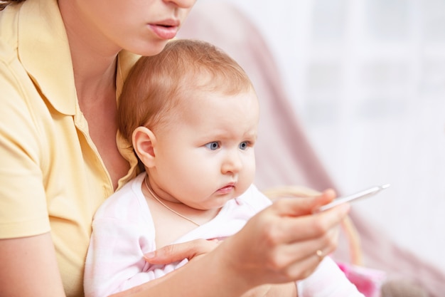 Una giovane donna per misurare la temperatura di un bambino