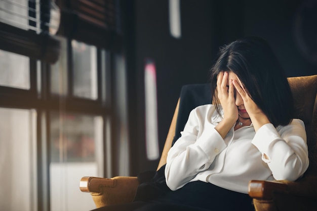 Una giovane donna professionista si copre la faccia e sottolinea i problemi che si presentano con lei