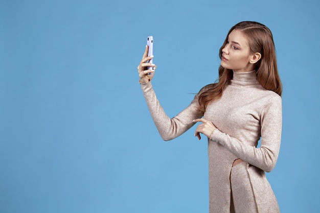 Una giovane donna si fa un selfie con il telefono